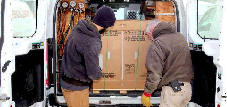 Advanced Comfort Systems loads air conditioner on truck for delivery and installation.